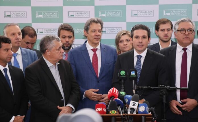 Hugo Motta (D) concede entrevista ao lado de Haddad e do líder do governo, José Guimarães
