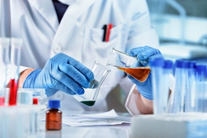 Pesquisador mistura líquidos num laboratório