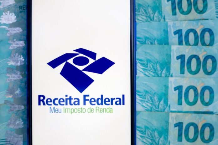 Notas de cem e a logomarca da Receita Federal