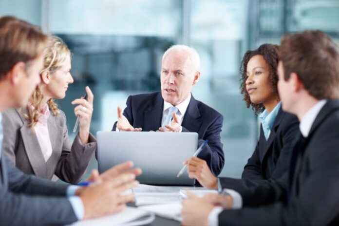Reunião de trabalho com pessoas sentadas à mesa