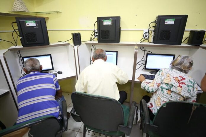 Idosos aprendendo a usar computadores