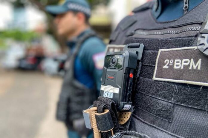 Policiais ao lado de viaturas