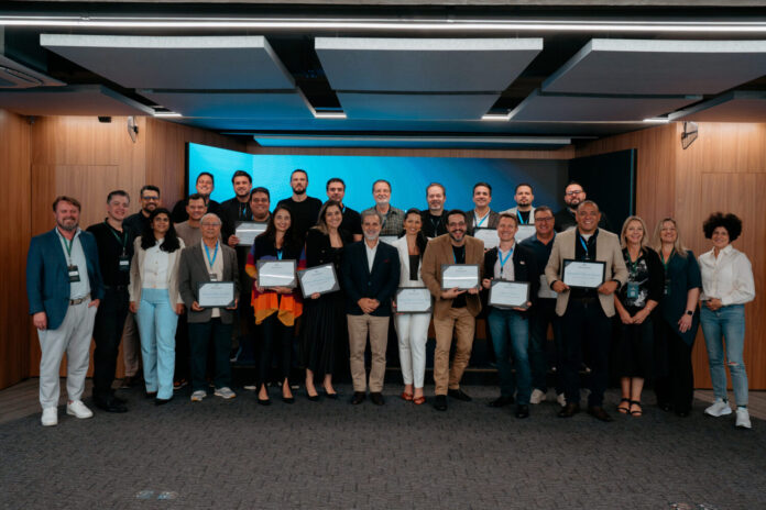 Formandos do programa Sala do Conselho posam juntos segurando seus certificados, simbolizando o avanço da governança corporativa e a formação de novos conselheiros consultivos no Brasil, sob coordenação de Márcio Giacobelli e o Advisory Board Institute.