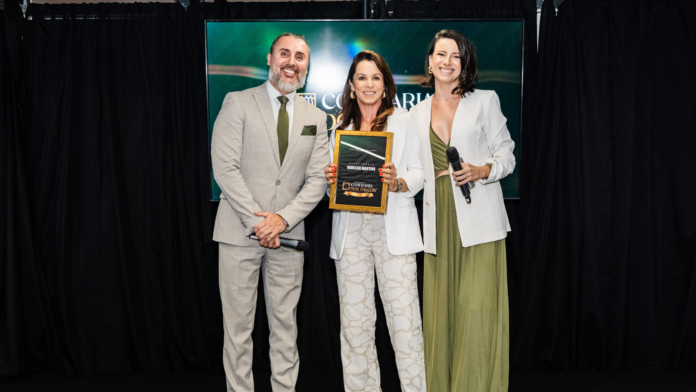 Mariléia Martins recebe reconhecimento durante participação na Confraria dos Palcos, ao lado de dois apresentadores em palco